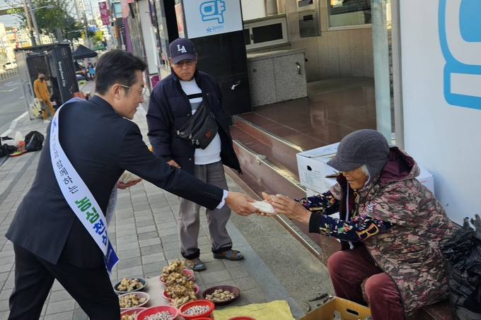 ▲ 김강훈 농협시지부장이 11일 상인에게 가래떡을 나눠주고 있다. 농협영천시지부 제공
