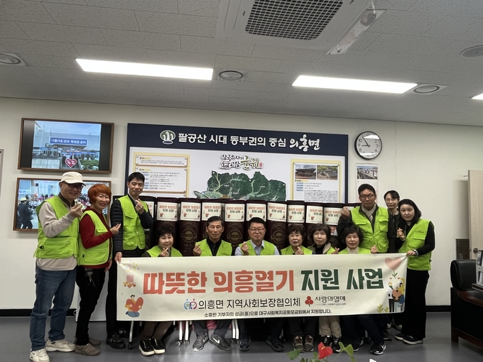 ▲ 대구 군위군 의흥면 지역사회보장협의체는 11일, 취약계층 24가구에 전기장판 24개를 지원하기 전에 기념촬영을 하고 있다. 군위군