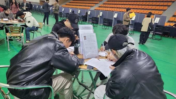 ▲ 12일 구미복합스포츠센터 다목적경기장에서 열린 ‘워크 인 구미(Work in GUMI) 취업매칭 데이’에 참여한 외국인 유학생들이 이력서를 작성하고 있다. 이봉한 기자