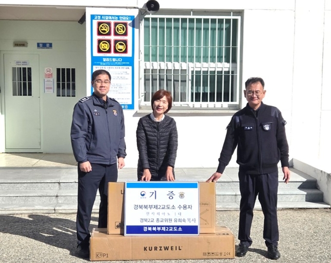 ▲ 유희숙 목사(가운데)가 경북북부제2교도소에 전자피아노를 기증하고 있다.