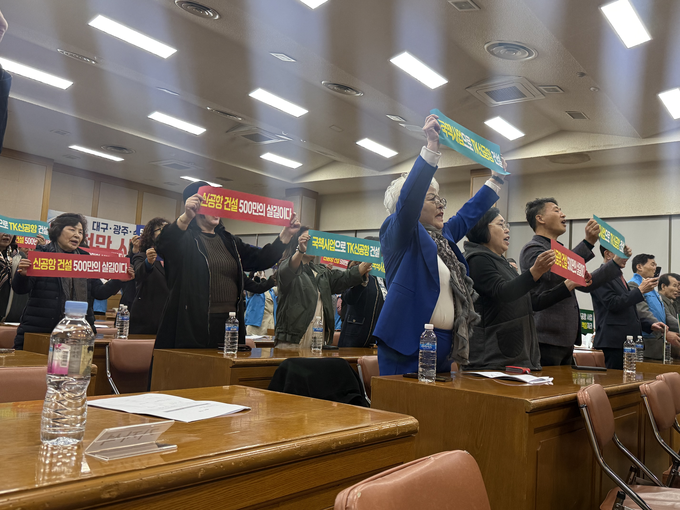 ▲ 12일 대구상공회의소에서 ‘3대 도시 군·민간공항 통합이전 성공 추진을 위한 공동연대’가 기자회견을 연 가운데 참석한 시민들이 피켓을 들고 호응하고 있다. 이유경 기자