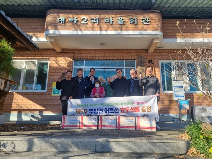 ▲ (사)우림일만 이상춘 이사장, 이우동 재경향우회 총장 겸 (사)우림일만 일일 이사장, 이종두 상록수나눔재단 이사, 김응숙 김천시의원이 참석한 가운데 부항면 행정복지센터에서 ‘효도 선물’을 전달하고 기년사진을 찍고 있다.