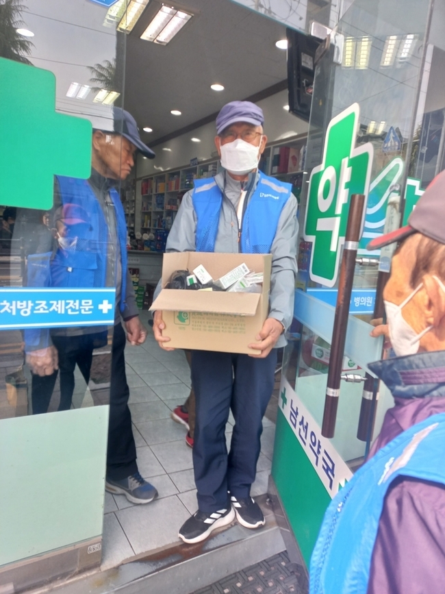 ▲ 김천시니어클럽이 운영하는  ‘폐의약품 수거봉사단’이 전용수거함의 폐의약품을 수고하고 있다.