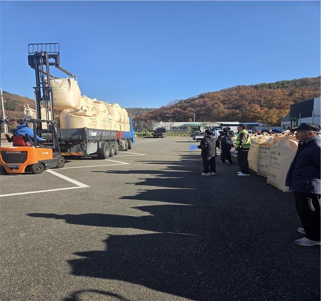 ▲ 12일 의성군 봉양면 중부농협 산지유통센터에서 작업자가 지게차로 톤백 포대를 대형 화물차에 적재하는 가운데, 농가와 관계자들이 매입 검수 절차를 지켜보고 있다. 의성군