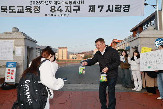 ▲ 13일 오전 김학동 예천군수가 수능 시험이 치러지는 예천여고 앞에서 수험생들을 응원하기 위해 작은 선물을 전달하는 장면, 예천군 제공