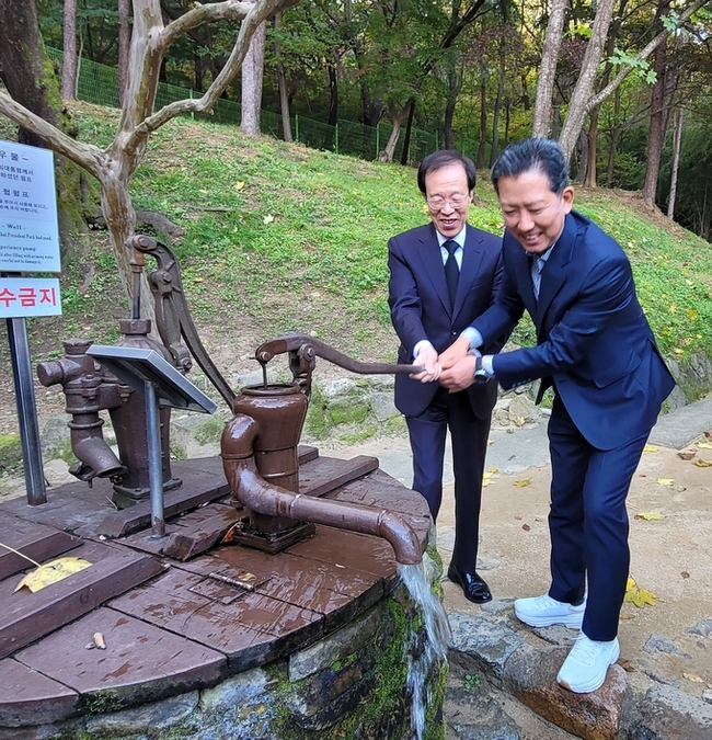 ▲ 박정희 생가를 방무한 이석연 국민통합위원장과 김장호 구미시장이 박정희 생가 우물가에서  국만통합을 위한 마중물을 이용 펌프질을 힘차게 하고있다. 이봉한기자