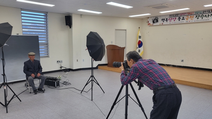 ▲ 산양면 지역사회보장협의체가 운영한 ‘행복산양 풍요금천 장수사진관’에서 어르신들이 장수사진 촬영을 준비하고 있는 모습.