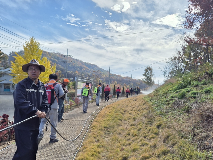 ▲ 12일 의성군 안사면사무소 인근 산자락에서 산불감시원들이 가을 낙엽이 쌓인 경사면을 따라 호스를 전개하며 실제 산불 대응 동선을 점검하는 훈련을 진행하고 있다. 의성군