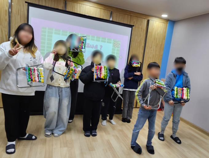 ▲ 김천시가족센터가 운영한 자녀 미래 설계 프로그램 ‘따뜻한 실로 그리는 미래’에 참여한 학생들이 만든 작품을 자랑하고 있다.