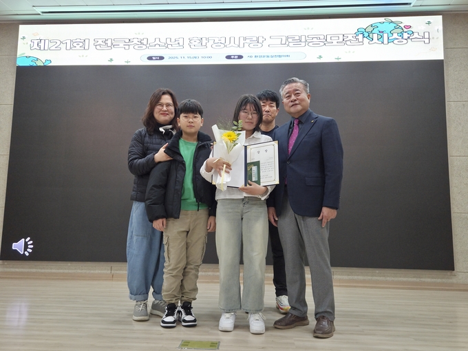 ▲ (사)환경운동실천협의회가 지난 15일 개최한 전국 청소년 환경사랑 그림공모전 시상식에서 대상을 차지한 정은지(호계중 2년·가운데) 학생이 김헌규 환실협 총재(오른쪽)  및 가족들과 기념촬영을 하고 있다. 환경운동실천협의회