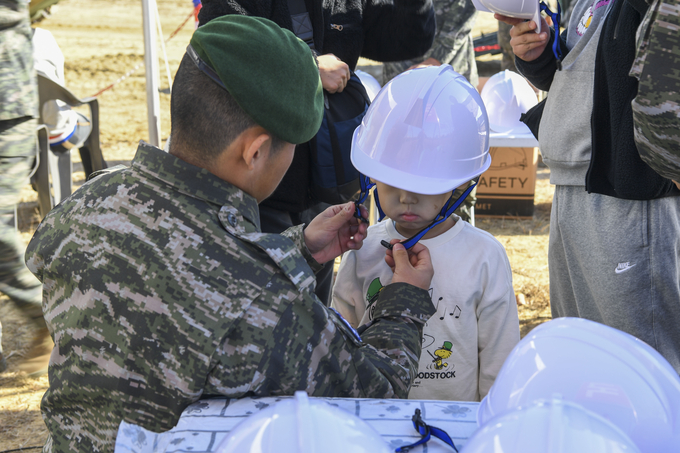 ▲ 2025 포항 해병대 문화축제가 지난 15일과 16일 양일간 성황리에 진행된 가운데 해병대원이 어린이에게 부스 프로그램에 참여 전 안전모를 씌워주는 모습. 해병대 1사단 제공