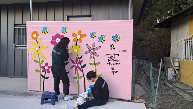 ▲ 초록별아트스쿨 회원들이 행복마을 벽화그리기기를 하고있다.