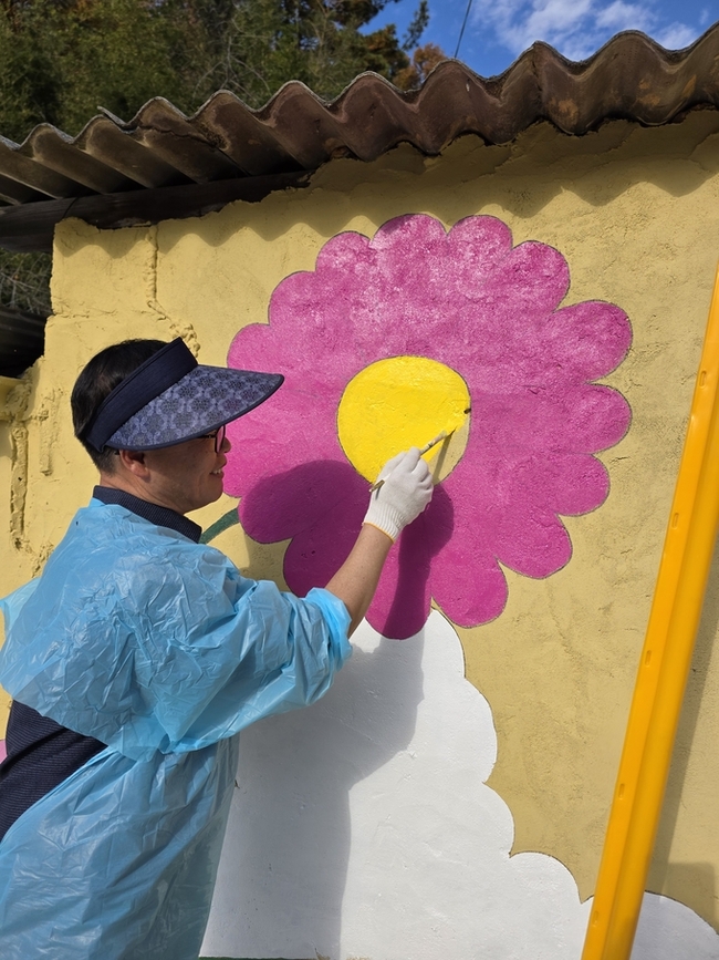 ▲ 김낙관 구미시의회 산업건설위원장이 선기동 행목마을 벽화그리기에 동참해 색을 입히고 있다.