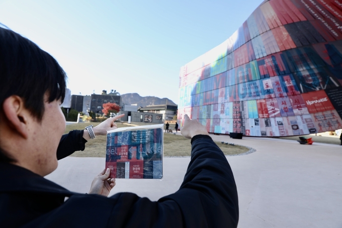 ▲ 시민이 휴머나이즈 월에서 마우스패드에 인쇄된 부분을 찾아 기념사진을 찍고 있는 모습