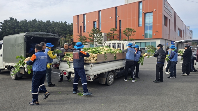 ▲ 포스코 포항제철소 에코팜봉사단원들이 직접 재배한 무를 전달하고 있다.