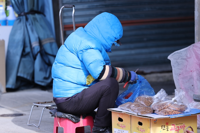 ▲ 17일 오전 기온이 낮아지고 찬 바람이 강하게 불면서 대구지역이 초겨울 날씨를 보인 가운데 대구 북구 칠성시장의 한 상인이 두터운 옷차림으로 일을 하고 있다.김영환 기자yhk@kyongbuk.com