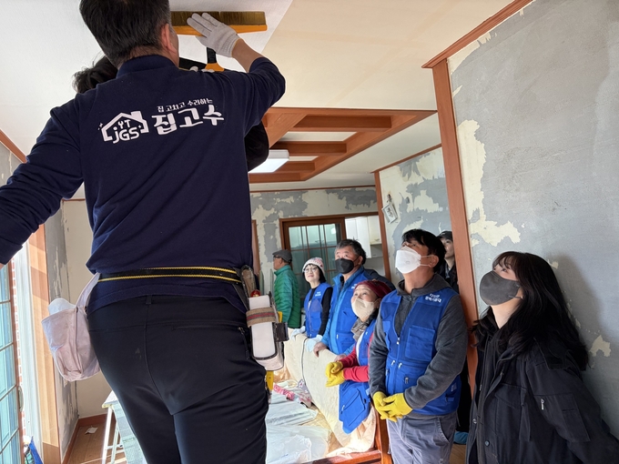 ▲ 17일 다인면 도배 교육 현장에서 전문 강사가 천장 초배 시공법을 시연하자 행복기동대원들이 작업 동작과 공구 사용법을 세밀하게 관찰하며 기술 습득에 집중하고 있다. 의성군