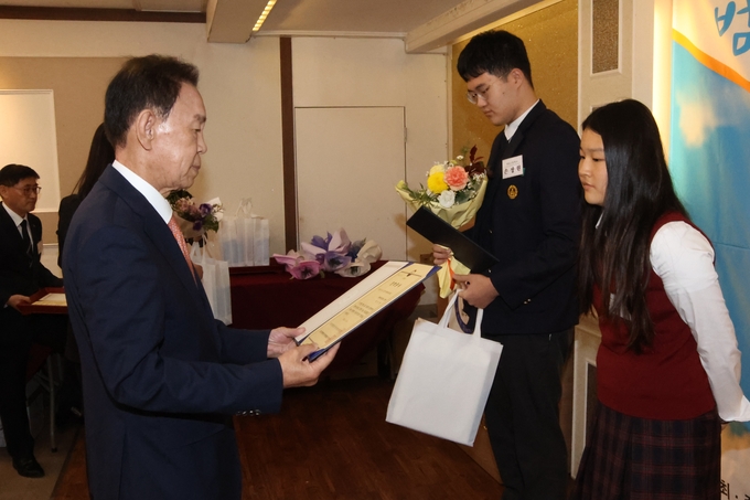 ▲ 박인환 경주범방 회장이 18일 열린 ‘2025 범죄예방 한마음대회’에서 모범 청소년에게 장학증서를 전달하고 있다. 경주범방