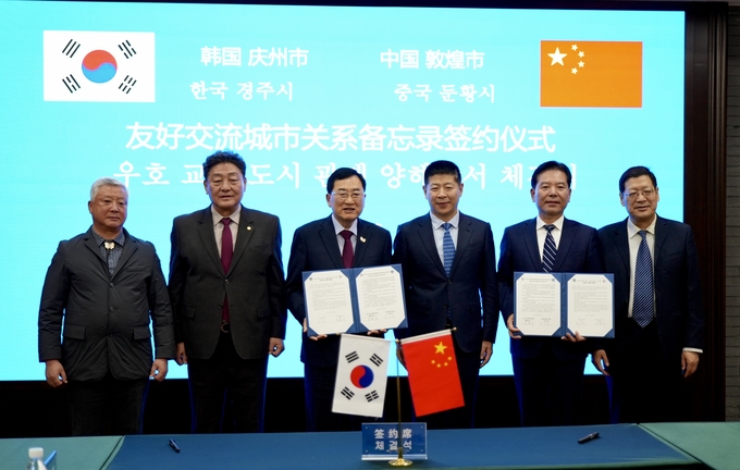 ▲ 주낙영 경주시장(왼쪽 세번째)과 주젠쥔 둔황시장(오른쪽 두번째)이 18일 둔황시청에서 경주시–둔황시 우호도시 협정서를 교환한 뒤 기념촬영을 하고 있다. 경주시