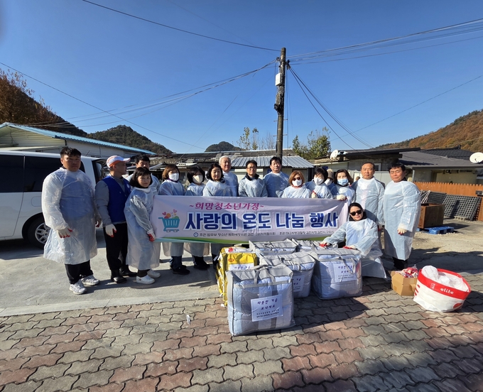 ▲ 김재혁 대구지방검찰청 김천지청장과 청소년 범죄예방위원회 구미지구 회원들이소외청소년 과정에 연탄과 쌀등을 지원하고 단체 기념촬영 하고있다.