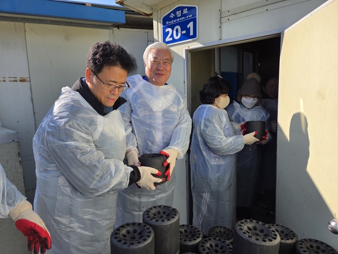 ▲ 대구지방검찰청  김재혁 김천지청장(왼쪽)과 문홍모 법부부 청소년범죄예방위원회 김천구미협의회장이 위원들과 함께 연탄을 옮기고 있다.