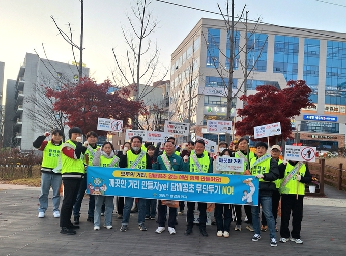 ▲ 예천군이 호명읍 걷고싶은거리 일대에서  환경관리과·보건소·호명읍 직원 20여 명과 ‘담배꽁초 무단투기 금지 캠페인 후 단체 기념촹영 장면, 예천군 제공