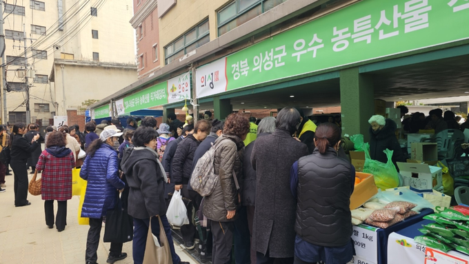 ▲ 21일 서울 종로구 조계사 인근에서 의성군 직거래장터를 찾은 시민들이 마늘, 사과, 가지, 장류, 버섯, 꿀, 누룽지, 차류, 고추장 등 의성 농특산물이 빼곡히 진열된 판매대 앞에 몰려들어 상품을 고르며 장날 특유의 북적이는 분위기를 연출했다. 의성군