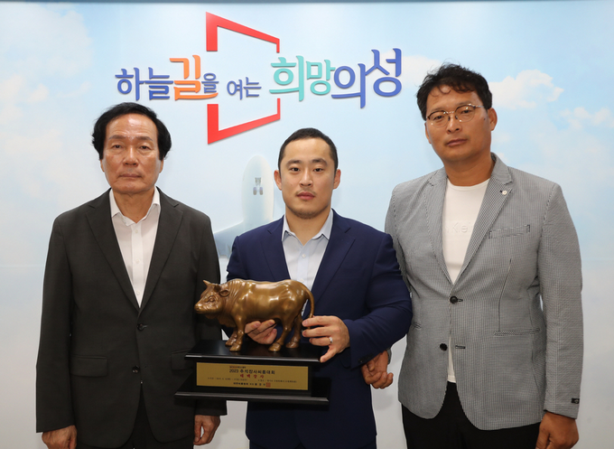 ▲ 2023 9월 15일 추석장사씨름대회에서 개인 통산 13번째 태백장사에 오른 의성군청 마늘씨름단 윤필재 선수(가운데)가 의성군청에서 우승 트로피를 들고 김주수 의성군수(왼쪽), 당시 배용수 감독(오른쪽)과 함께 기념촬영을 하고 있다. 경북일보 DB