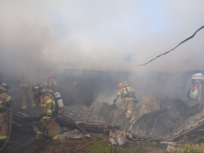 ▲ 22일 경북 의성군 단촌면 세촌리 주택 화재 현장에서 소방대원들이 무너져 내린 지붕 잔해를 헤치며 진화 작업을 이어가고 있다. 의성소방서