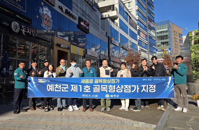 ▲ 예천군이 도청 신도시 중심상권인 ‘새움로’를 군 최초의 골목형상점가로 지정 한후 김경보   경제농림국장과 최영종 지역경제과장, 관계자들이 새움로 앞에서 단체 기념촬영 장면, 예천군 제공