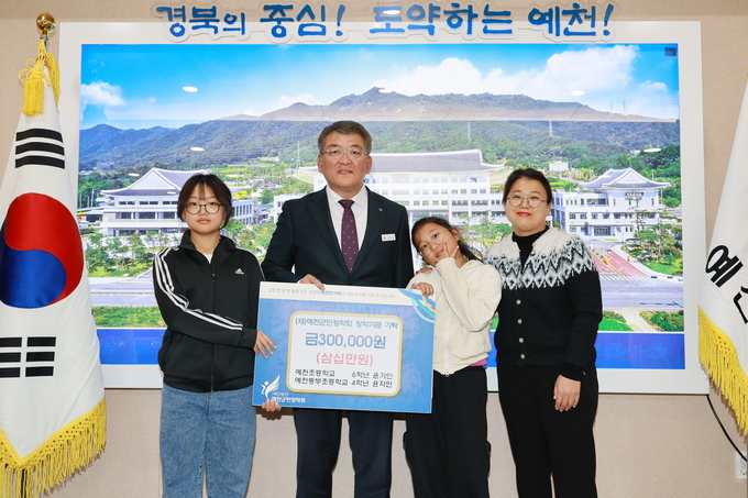 ▲ 21일 예천초 6학년 윤가인, 예천동부초 4학년 윤지인 자매는 예천군청을 찾아 예천군민장학회(이사장 김학동 예천군수)에 30만 원을 기탁 한후 김학동 군수와 사진촬영 포즈를 취하는 장면, 예천군 제공