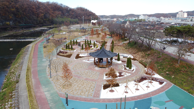 ▲ 경북 의성군 남대천변 구봉공원에서 드론으로 촬영한 도시숲 조성 구역이 정자와 산책로, 침수 대응형 수종 배치가 어우러진 원형 구조로 정비된 모습이 넓게 펼쳐지고 있다. 의성군