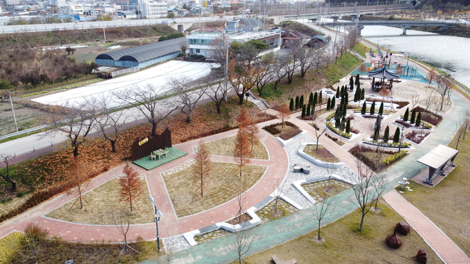 ▲ 경북 의성군 구봉공원에서 드론으로 내려다본 도시숲 전경이 지형 경사와 하천 인접 환경을 고려한 교목·관목 식재 구조와 휴식 데크 배치가 조화를 이루며 조성된 흐름을 보여주고 있다. 의성군