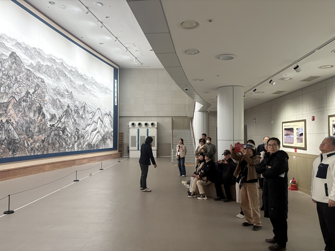 ▲ 팸투어 참가자들이 청송 출신 고 이원좌 화백의 작품 청량대운도를 관람하고 있다.