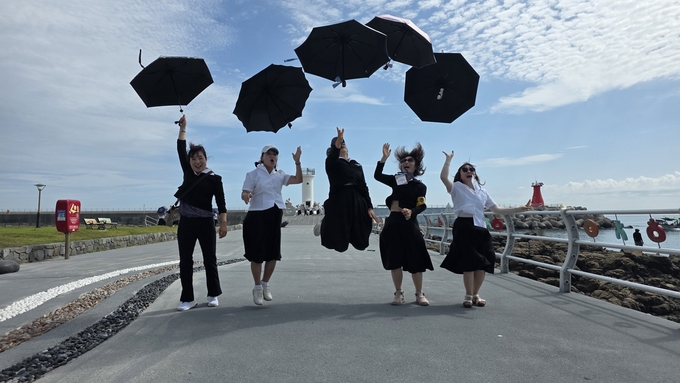 ▲ 신라문화원이 진행한 ‘2025 추억의 경주 수학여행’에 참가한 이현승 노래교실 회원들이 감포항에서 기념촬영을 하고 있다. 신라문화원