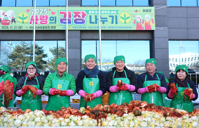 ▲ 21일 경북 의성군새마을회관 앞에서 박화자 의성군의회 의원(왼쪽부터), 박희용 새마을회장, 김주수 의성군수, 권민재 지원장, 최훈식 의성군의회 의장, 박선희 의원 등이 ‘2025 사랑의 김장나눔’ 행사에 참여해 막 버무린 김장김치를 들어 보이며 미소를 짓고 있다. 의성군